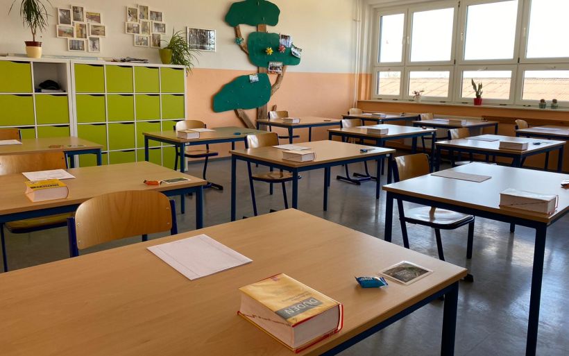 Blick in ein Klassenzimmer, in dem die Tische für die Prüfungen vorbereitet wurden.