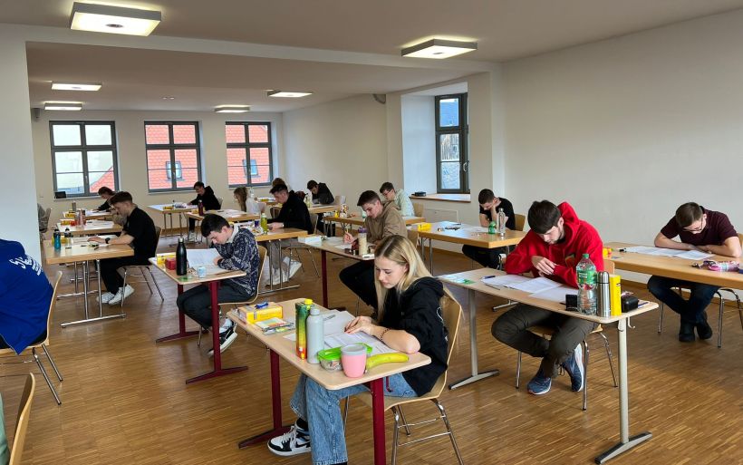 Schülerinnen und Schüler sitzen in einer Prüfung
